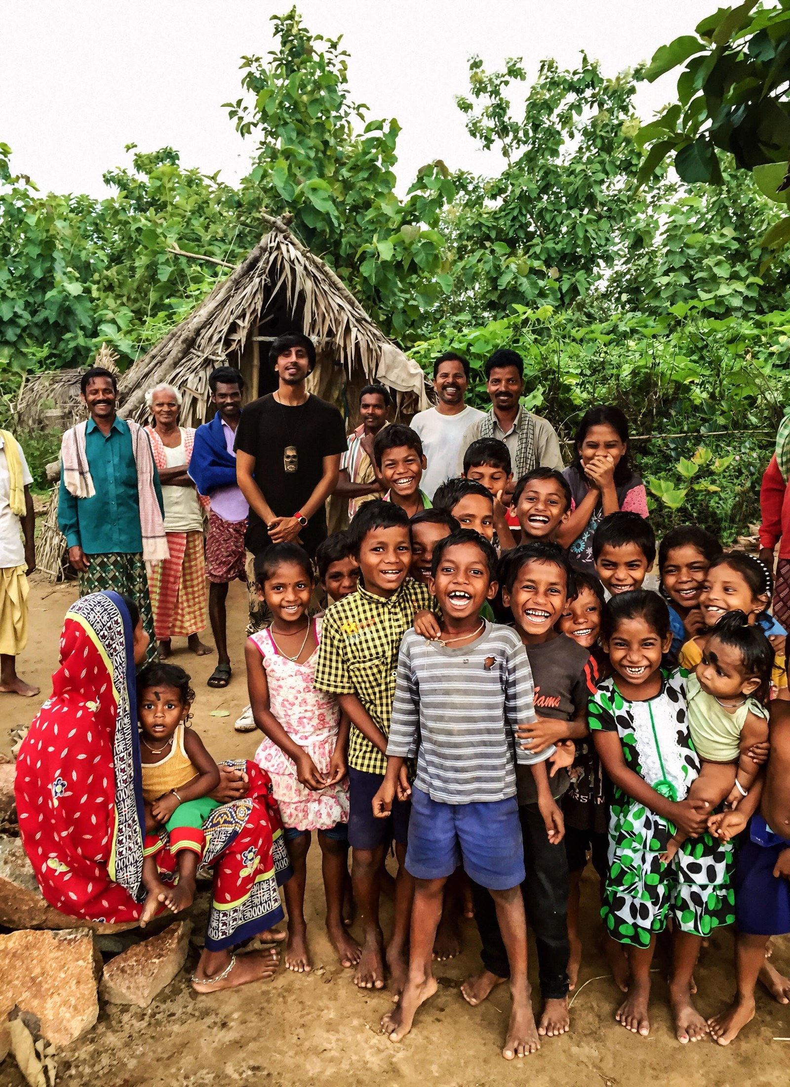 Fam Mirza with children and community members outdoors