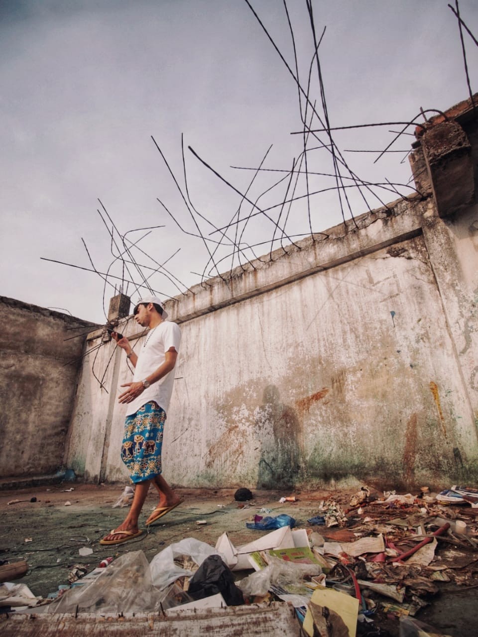 Fam Mirza standing beside a weathered wall outdoors